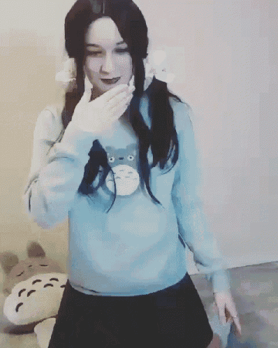 a woman in a blue sweater and black skirt is kneeling down and laughing