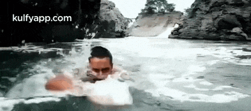 a man is swimming in a river with a foamy face .