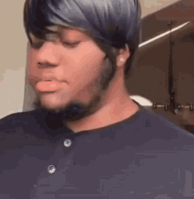 a man with a beard and a wig is making a face .