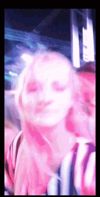 a blurry picture of a woman 's face with a pink background