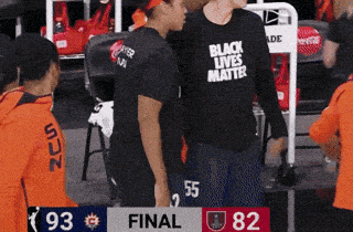 a man wearing a black lives matter shirt stands next to a woman