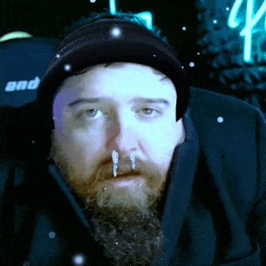 a man with a beard is wearing a black jacket and a black beanie