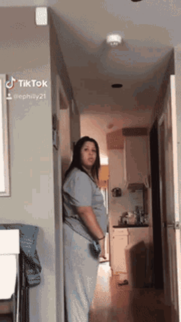 a woman is standing in a hallway with a tiktok watermark