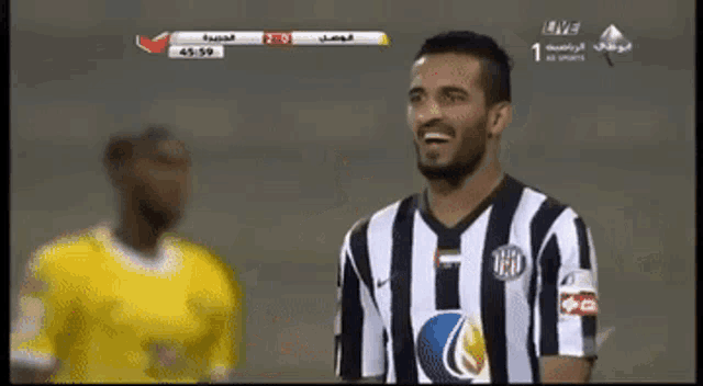 a soccer player wearing a black and white striped jersey with the number 1 on the front