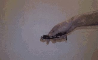 a person is holding a knife in their right hand against a wall .