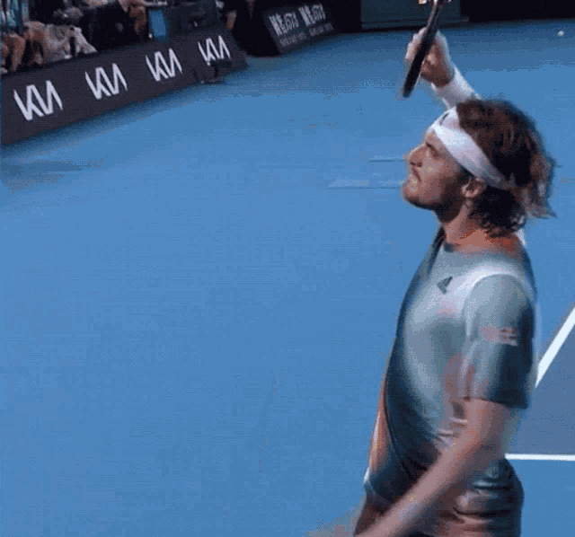 a man holding a tennis racquet on a blue court