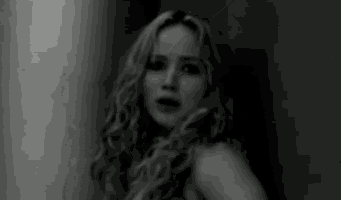 a black and white photo of a woman with long curly hair .