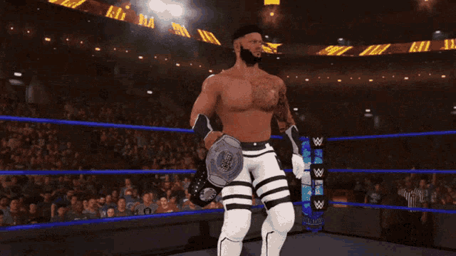 a man in a wrestling ring holds a belt that says intercontinental heavyweight champion