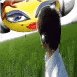 a man wearing headphones stands in front of a yellow car with a woman 's face on it