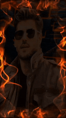 a man wearing sunglasses and a leather jacket is surrounded by flames