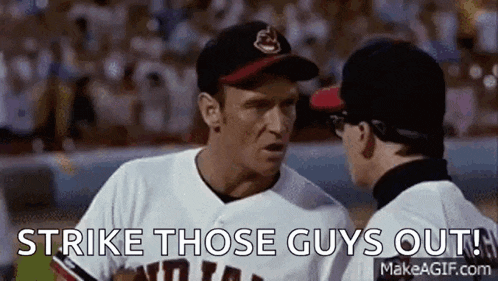 two baseball players are talking to each other on a field and one of them is saying `` strike those guys out ! ''