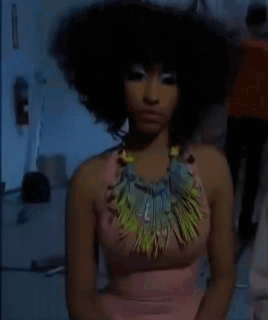 a woman in a pink dress and a colorful necklace
