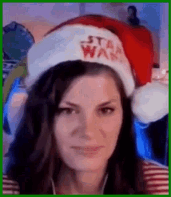 a woman is wearing a santa hat with the word star wars on it .