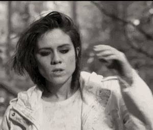 a black and white photo of a woman wearing a white jacket and a white t-shirt .