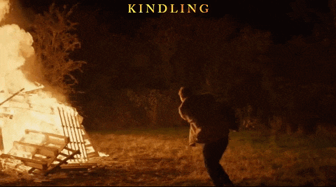 a poster for kindling shows a man walking in front of a fire