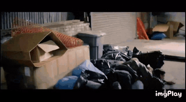 a pile of garbage bags and boxes on a sidewalk with the words imgplay at the bottom