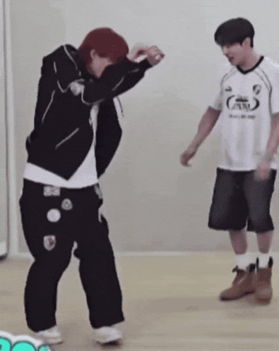 two young men are dancing in a room .