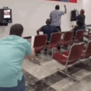 a group of people are sitting in a waiting room with a tv on the wall .