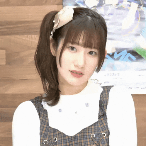 a close up of a girl 's face with a poster behind her