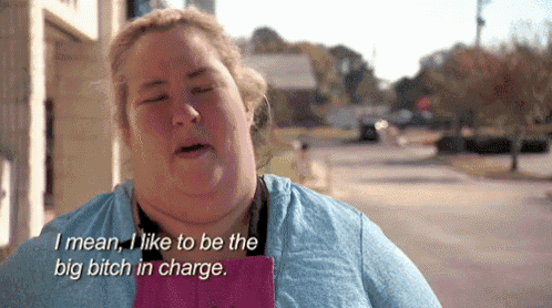a woman in a blue shirt is saying i mean i like to be the big bitch in charge