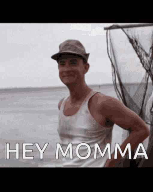 a man wearing a hat and a tank top with the words hey momma below him