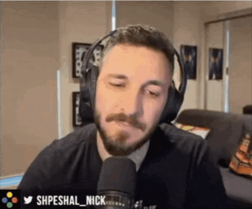 a man with a beard is wearing headphones and looking at the camera