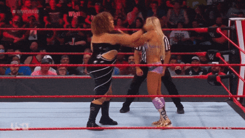 two wrestlers are fighting in a wrestling ring with a referee watching