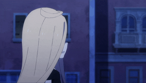 a woman with long blonde hair stands in front of a purple building