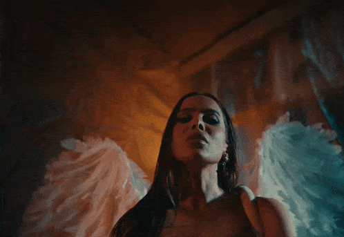 a woman in a white dress with angel wings on her back