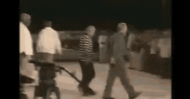 a blurry picture of a group of people walking down a street at night .