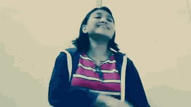 a woman wearing a striped shirt and a black jacket is smiling