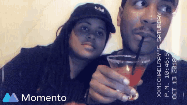 a man and a woman are holding a drink in a momento photo