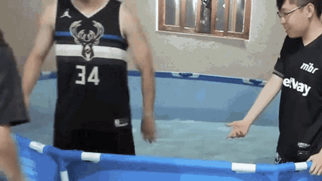 a man in a 34 jersey is standing in a pool