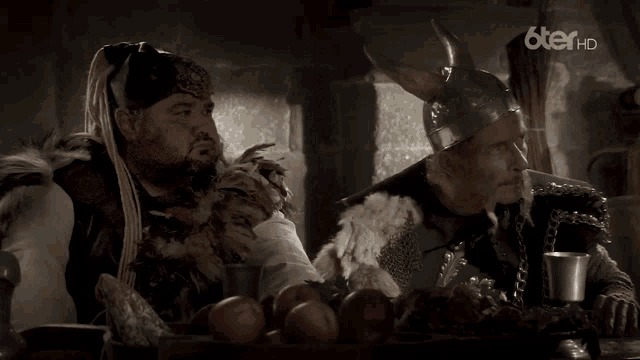 two men in viking costumes are standing next to each other and the words il est d' accord are on the screen