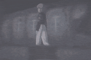 a man in a black shirt and white pants stands in a dark room in front of a window