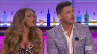 a man and a woman are sitting in front of a bar .