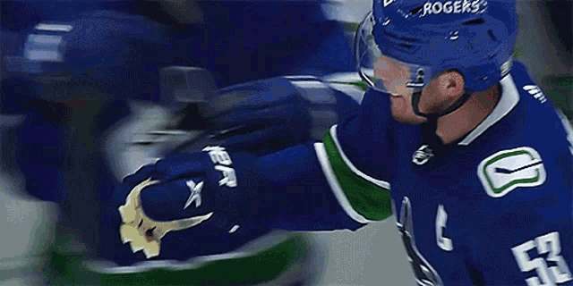 a hockey player wearing a blue jersey with the number 27 on it