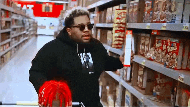 a man standing in a grocery store looking at a box of pringles cereal