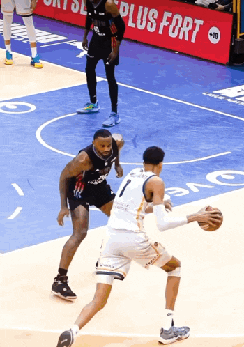 a basketball game is being played in front of a plus fort sign