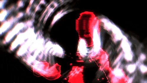 a red and white swirl in the dark with a person standing in the middle