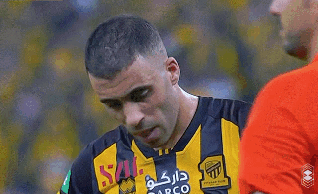 a soccer player wearing a yellow and black jersey with darco on it