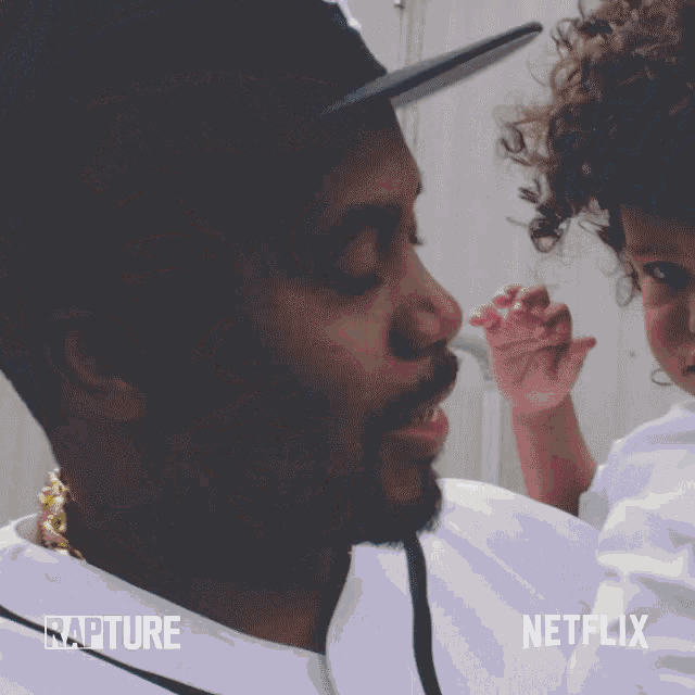 a man holding a baby with rapture and netflix written on the bottom right