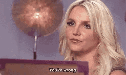 britney spears is sitting in front of a purple box and says `` you 're wrong '' .
