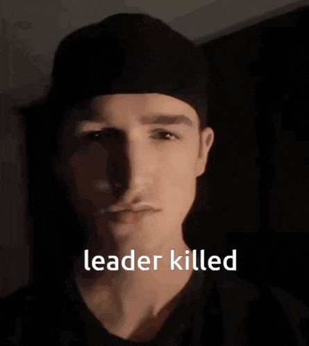 a man wearing a black hat and a black shirt with the words leader killed on his face