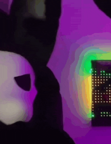 a black and white stuffed animal is sitting in front of a sign that says ' i love you '