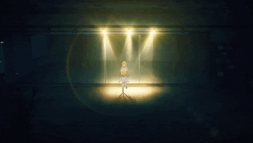 a person is standing in a dark room with a spotlight on them