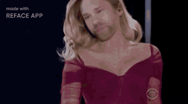 a man with a beard is wearing a woman 's dress and wig .