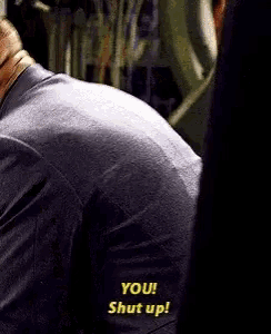 a close up of a man 's back with the words " you shut up " written on it