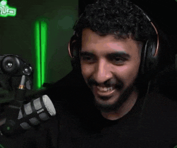 a man with headphones is drinking from a glass .