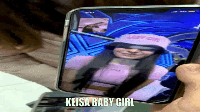 a person is holding a cell phone with a picture of a girl and the words keisa baby girl